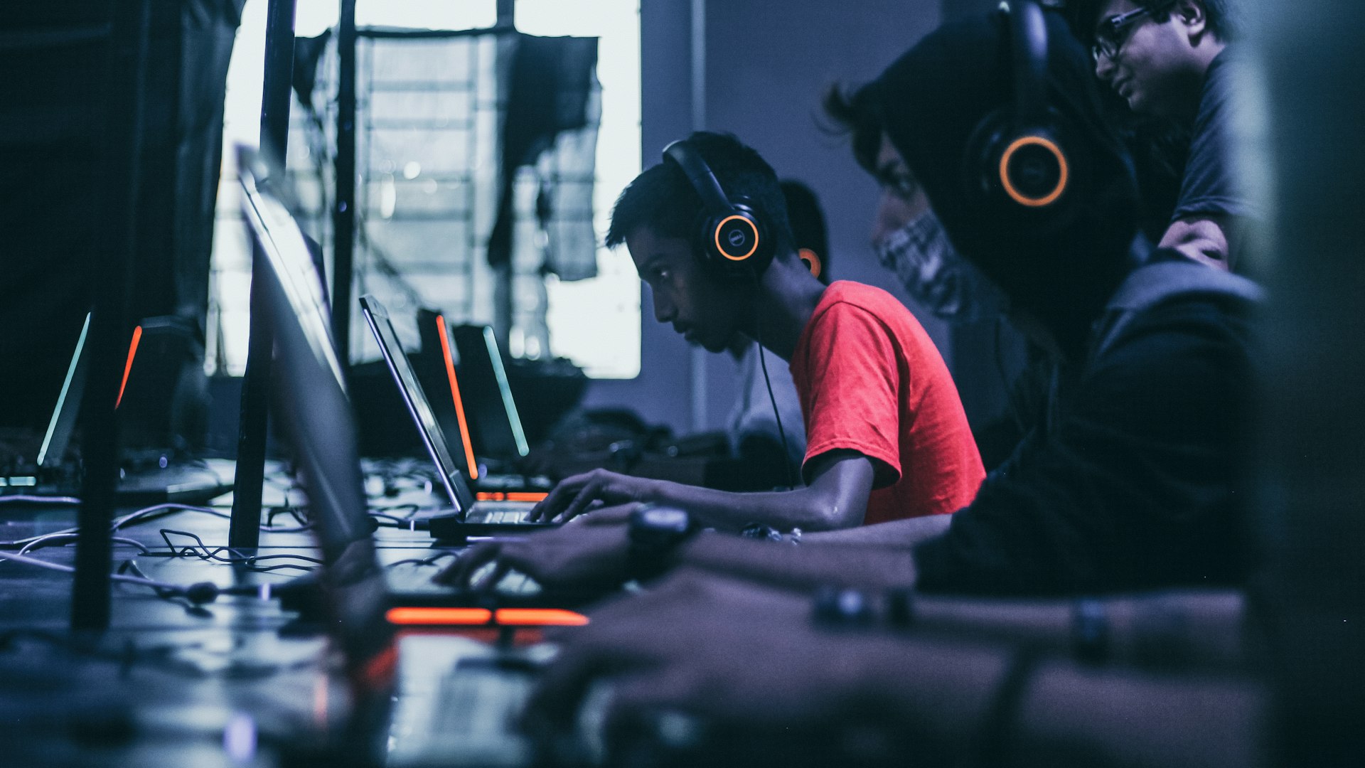 Gamers competing at illuminated battlestations inside the Crystal Quest Dynasty arena